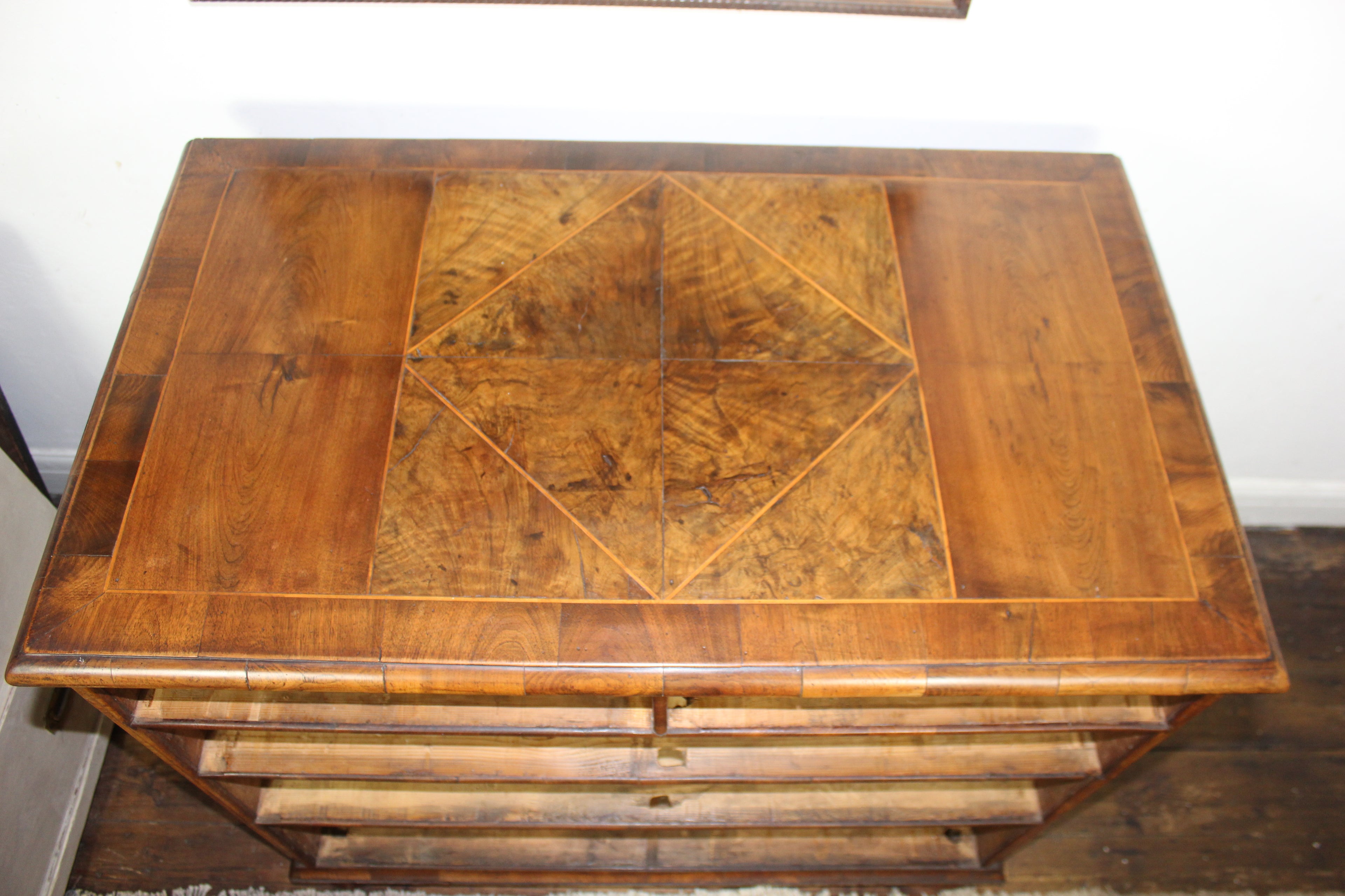 detail of burr walnut veneers showing rich grain and patina on antique chest of drawers